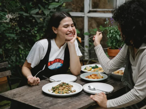 A person offering food to another