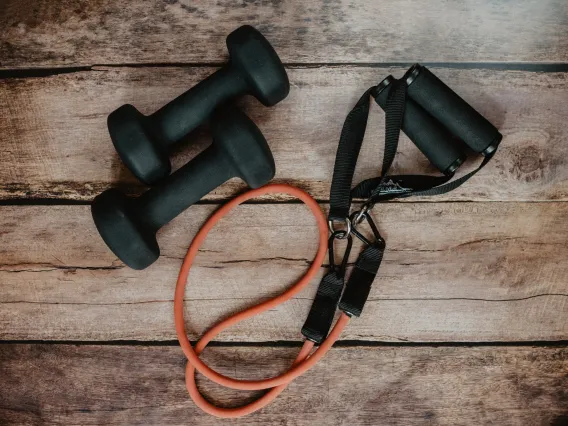 Workout band and 2 dumbells on hardwood floors