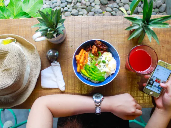 person using phone in front of meal