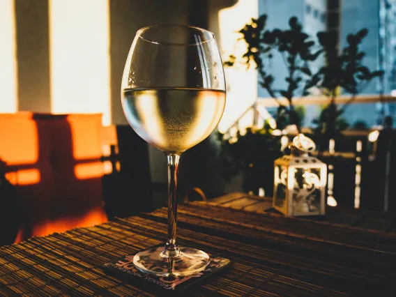 Glass of wine on a table with sunlight shining on it