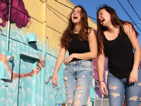 Two people walking outside and laughing together