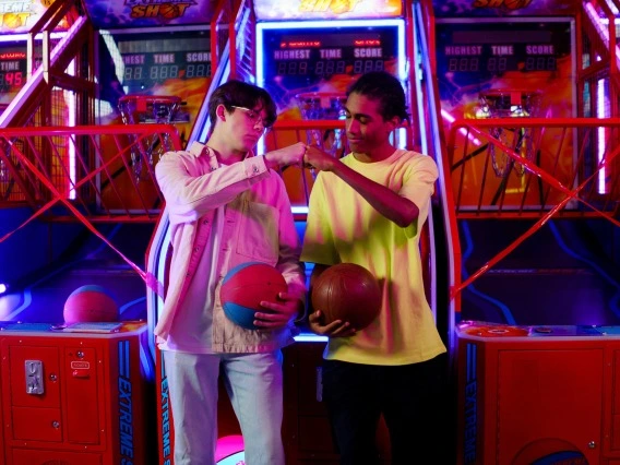 Two people fist pumping at an arcade 