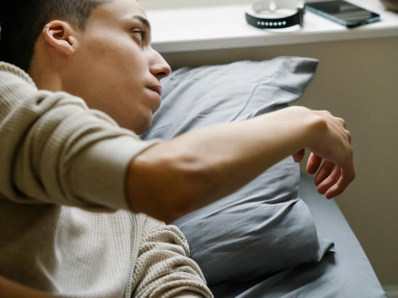 Young man checking gadgets after awakening