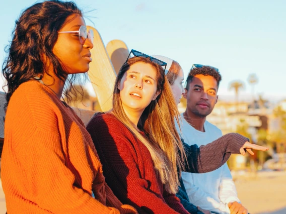Woman in Red Sweater Looking at the Woman Wearing Sunglasses