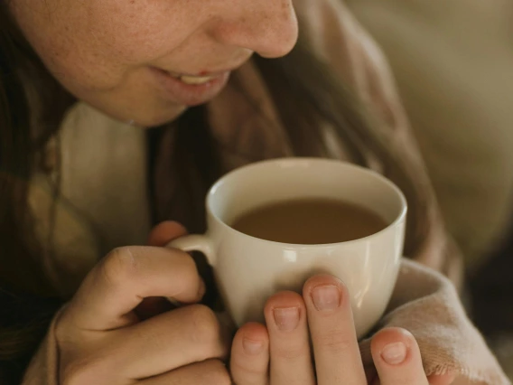 person holding a cup of coffee to their face