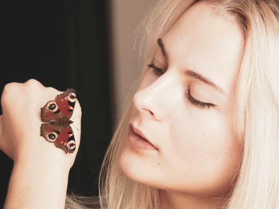 a person looking at a butterfly that has landed on their hand