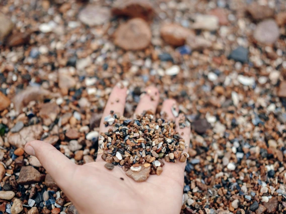 close-up of a person's hand holding a handful of sand
