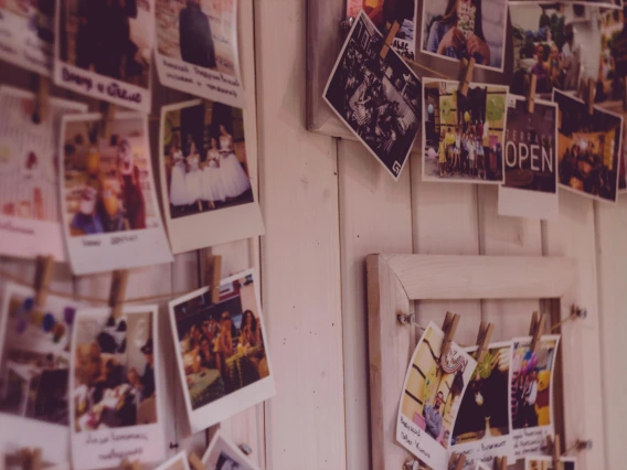 photographs hanging from a string pinned to a wall