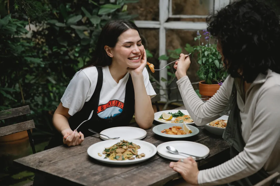 A person offering food to another