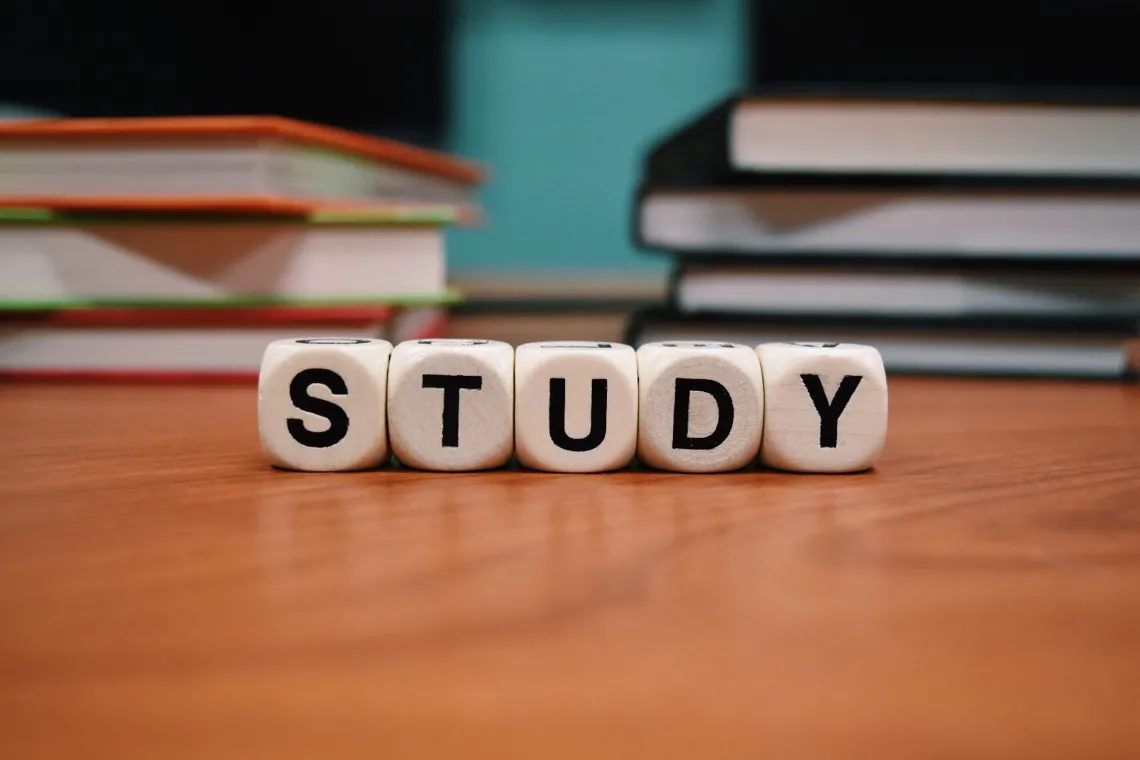 Alphabet blocks saying study with books behind