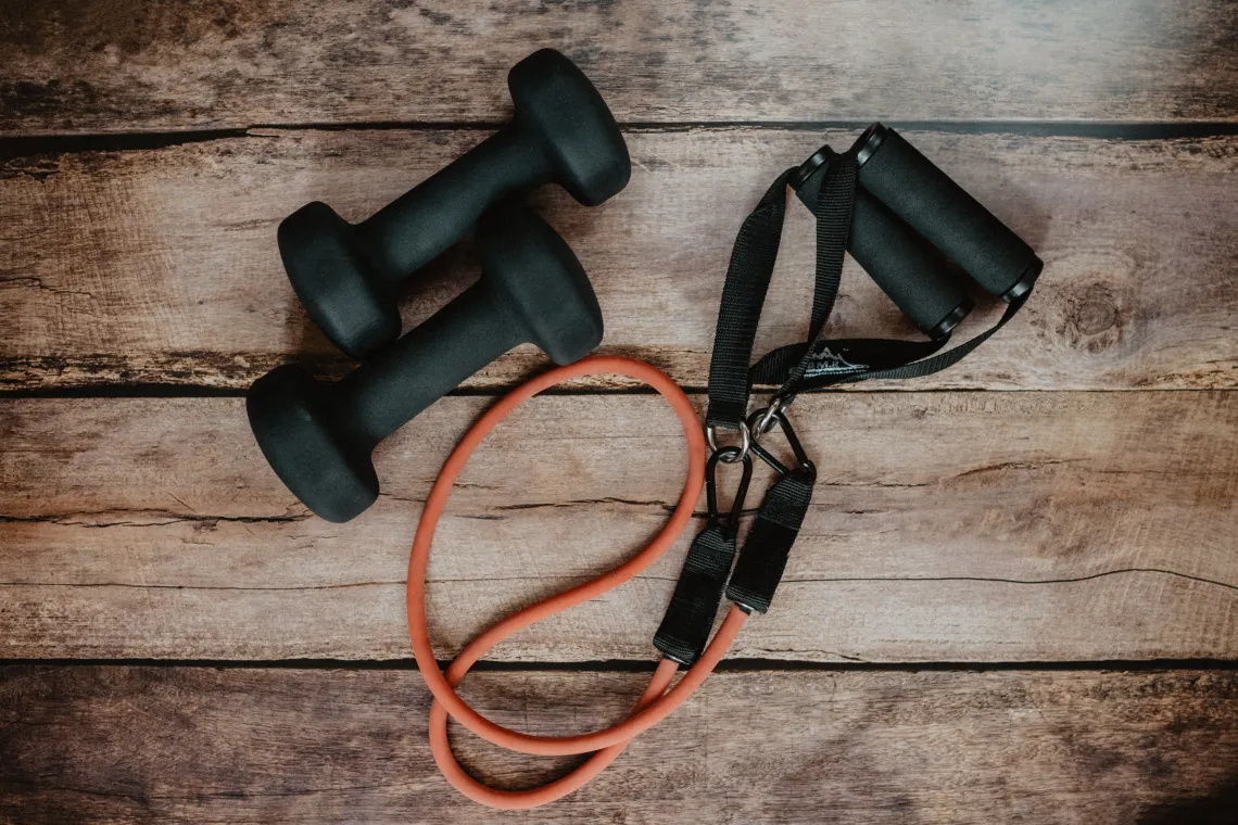 Workout band and 2 dumbells on hardwood floors