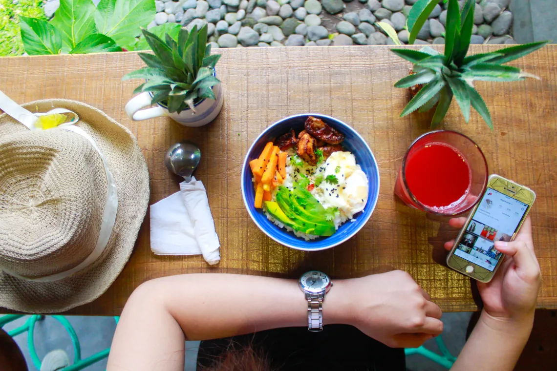 person using phone in front of meal