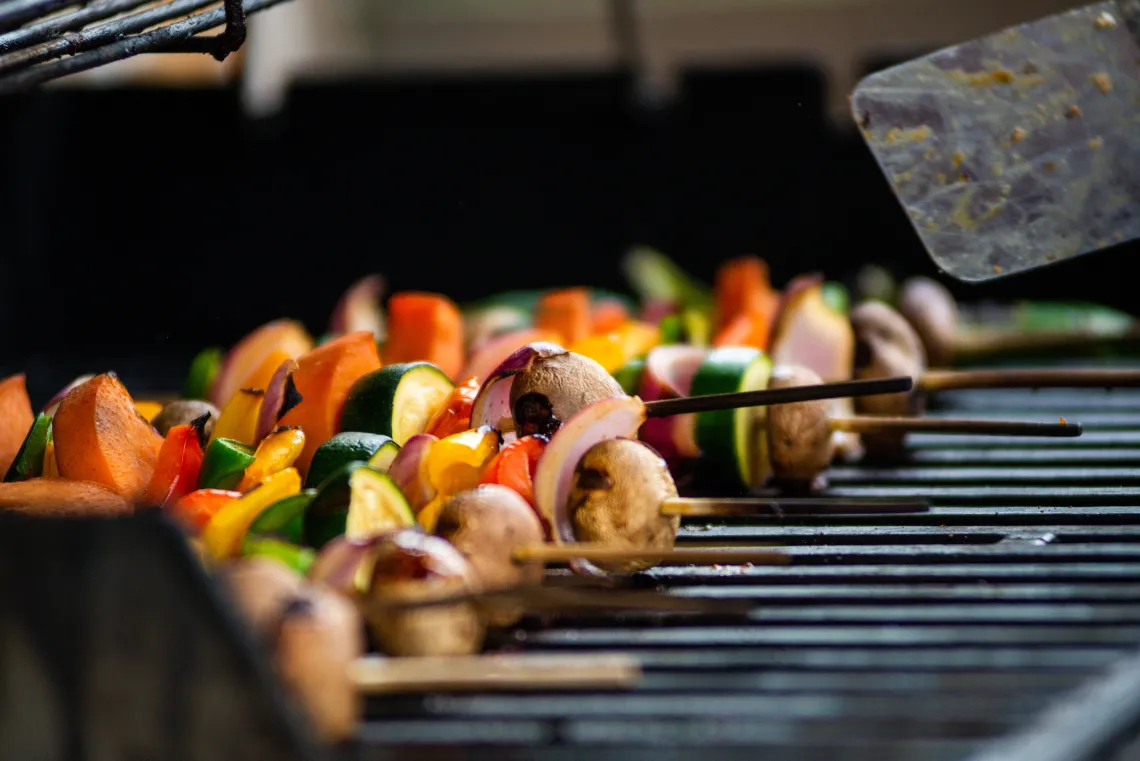 Kabobs with peppers, zuchinni, meat, and mushrooms on a grill