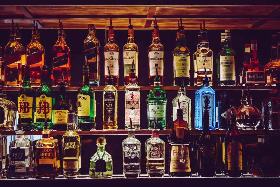 Liquor displayed on a shelf behind a bar