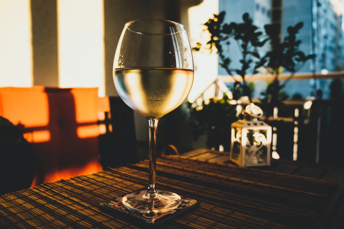 Glass of wine on a table with sunlight shining on it