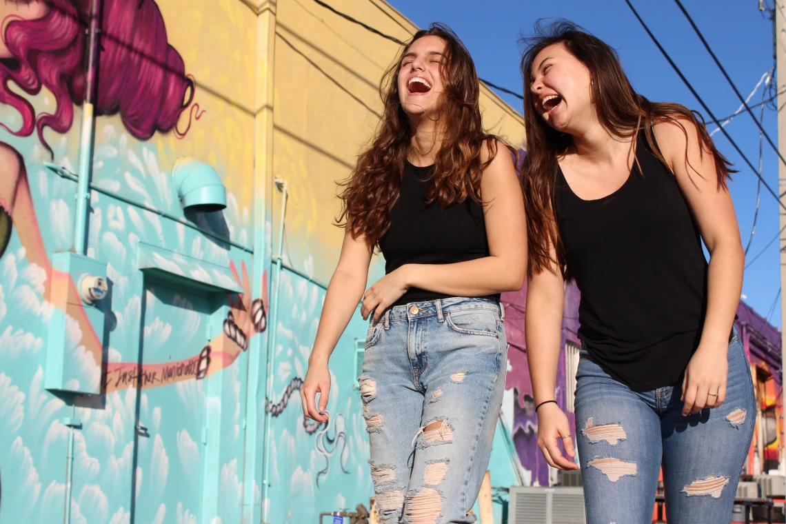 Two people walking outside and laughing together