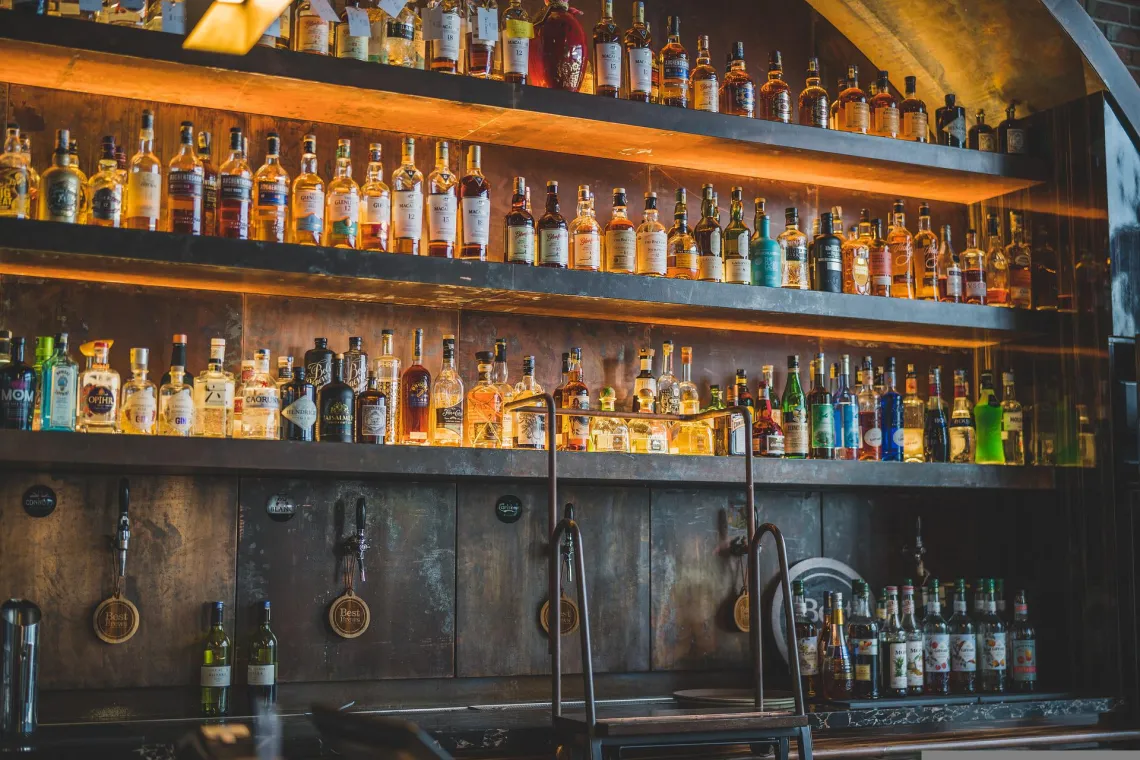 Liquor on bar shelf with beer taps underneath