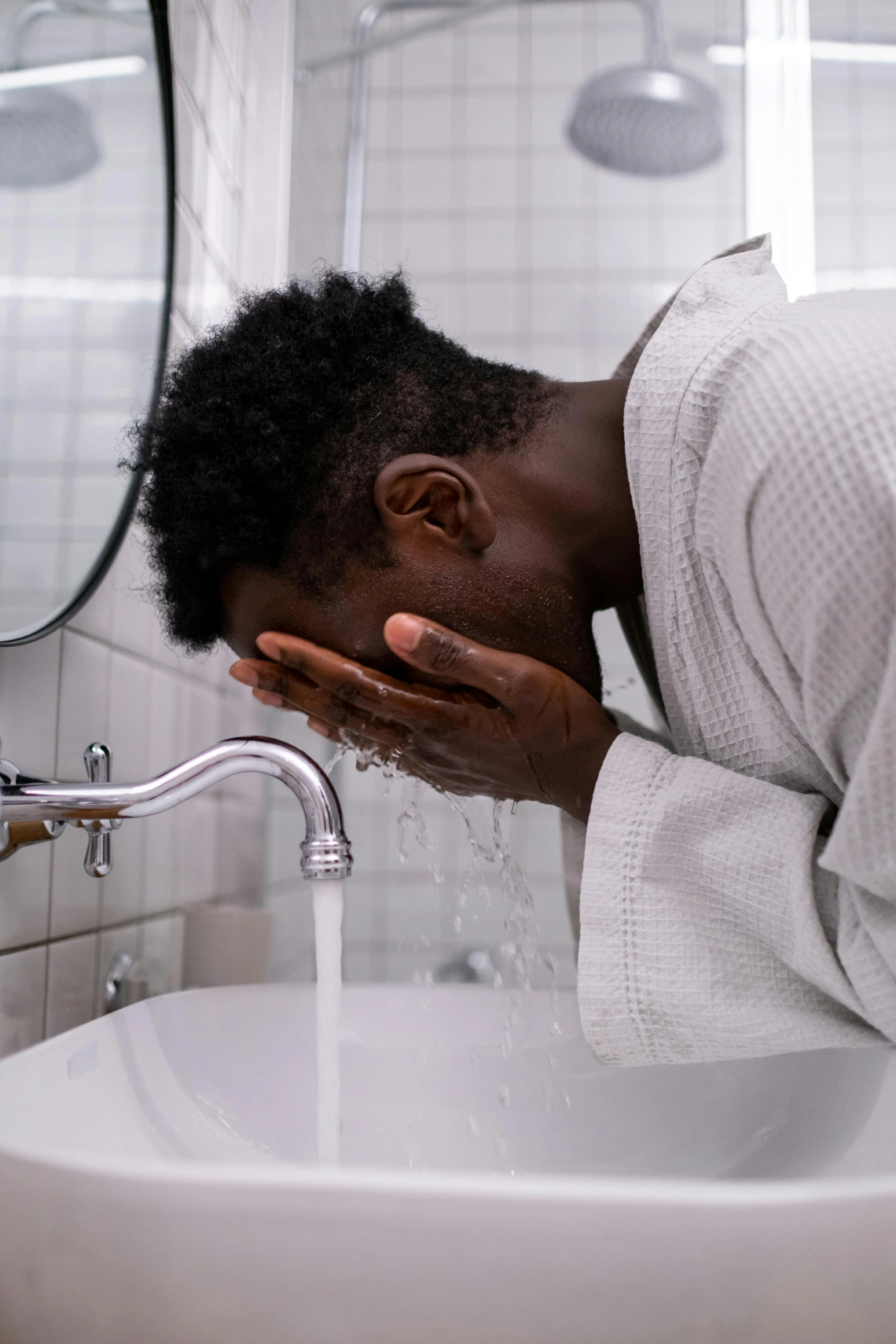 Young man washing his face. 