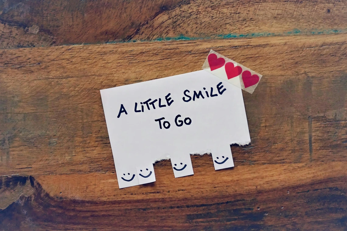 index card with the text "a little smile to go" written across it