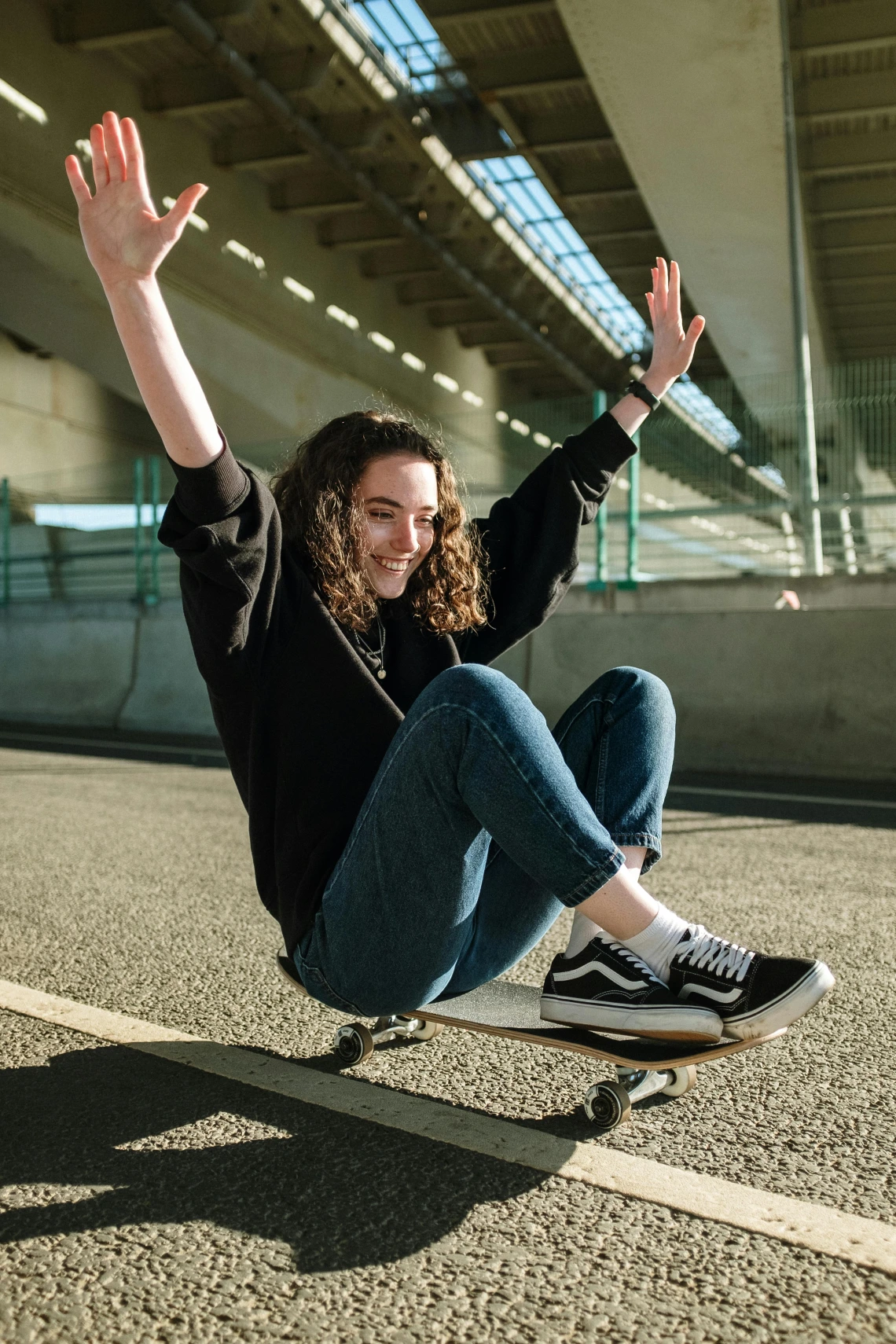 person sitting on a skateboard with their hands in the air