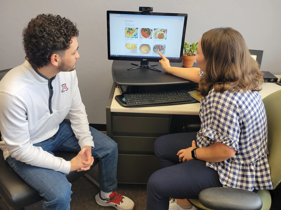 student and dietitian looking at recipes on a computer