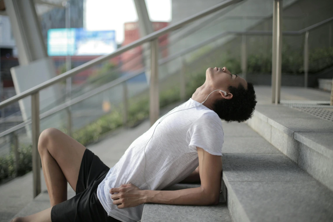 person sitting on an outdoor staircase looking at the sky