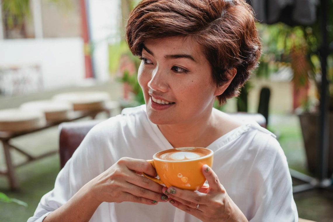 Person looking off to the side holding a mug